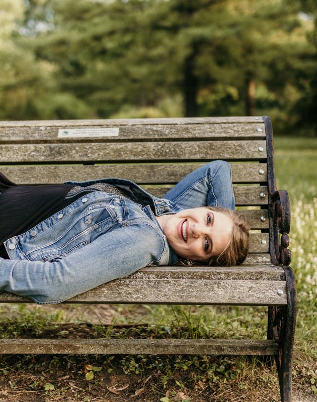 Female model laughing on a park bench